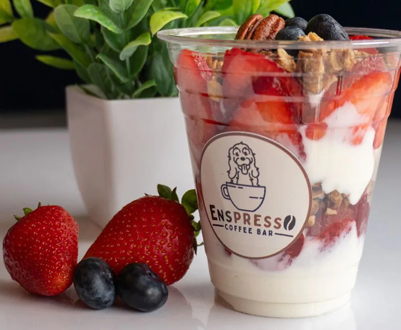 Vaso de yogur con fresas, moras azules, granola y nuez
